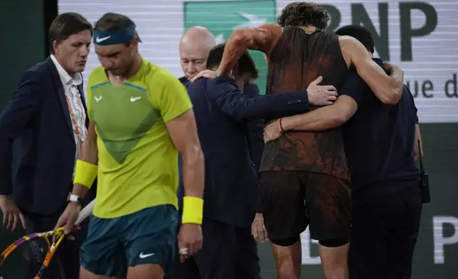 FILE - Germany's Alexander Zverev is carried off the court after twisting his ankle during the semifinal match against Spain's Rafael Nadal, left, at the French Open tennis tournament in Roland Garros stadium in Paris, France, Friday, June 3, 2022. Rafael Nadal is in the French Open field, after all, and the 14-time champion was set up for a challenging first-round matchup in Thursday’s draw against Alexander Zverev. (AP Photo/Christophe Ena)