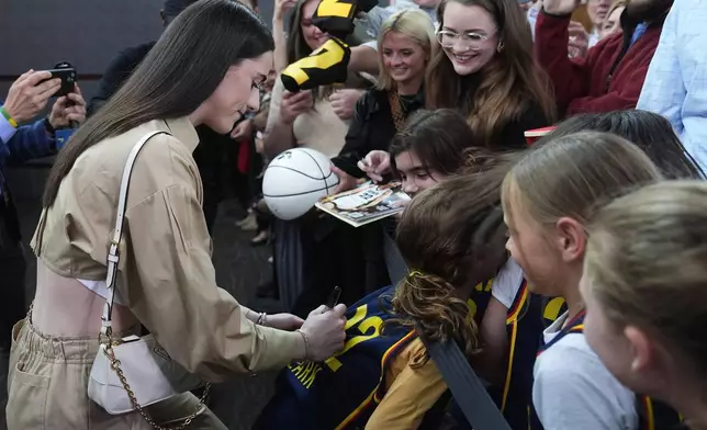 Indiana Fever's Caitlin Clark, left, gives autographs as she arrives on the Red Carpet before the world premiere and screening of Episode 1 of the upcoming ESPN+ Original Series Full Court Press, Monday, May 6, 2024, in Indianapolis. (AP Photo/Darron Cummings)
