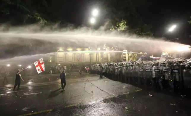 Riot police use a water cannon during an opposition protest against "the Russian law" near the Parliament building in Tbilisi, Georgia, on Wednesday, May 1, 2024. Clashes erupted between police and opposition demonstrators protesting a new bill intended to track foreign influence that the opposition denounced as Russia-inspired. (AP Photo/Zurab Tsertsvadze)