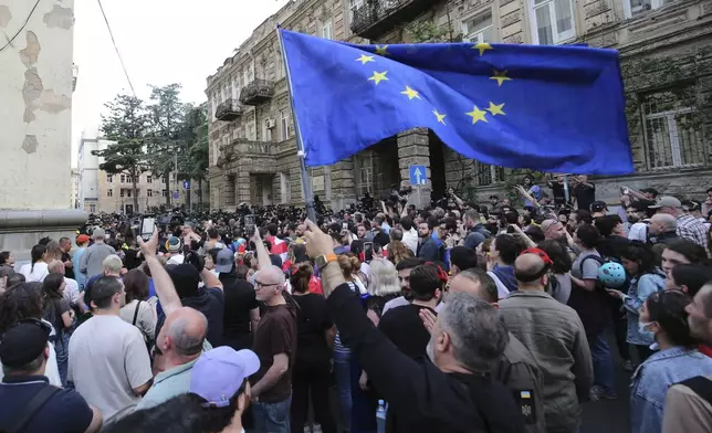 Demonstrators blocked by the police wave a EU flag during an opposition protest against "the Russian law" near the Parliament building in Tbilisi, Georgia, on Wednesday, May 1, 2024. Protesters denounce the bill as "the Russian law" because Moscow uses similar legislation to stigmatize independent news media and organizations critical of the Kremlin. (AP Photo/Zurab Tsertsvadze)