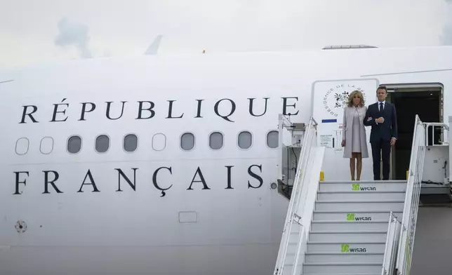 French President Emmanuel Macron and his wife Brigitte Macron arrive at the military section of BER Airport, in France, ahead of their three-day state visit to Germany, Sunday, May 26, 2024. (Christophe Gateau/dpa via AP)