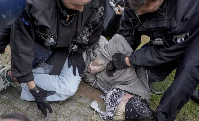 A person is taken in custody by police officers during a pro-Palestinians demonstration by the group "Student Coalition Berlin" in the theater courtyard of the 'Freie Universität Berlin' university in Berlin, Germany, Tuesday, May 7, 2024. Pro-Palestinian activists occupied a courtyard of the Free University in Berlin on Tuesday. (AP Photo/Markus Schreiber)
