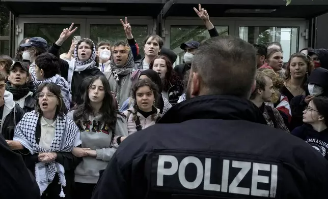 Participants face German police officers during a pro-Palestinians demonstration by the group "Student Coalition Berlin" in the theater courtyard of the 'Freie Universität Berlin' university in Berlin, Germany, Tuesday, May 7, 2024. Pro-Palestinian activists occupied a courtyard of the Free University in Berlin on Tuesday. (AP Photo/Markus Schreiber)