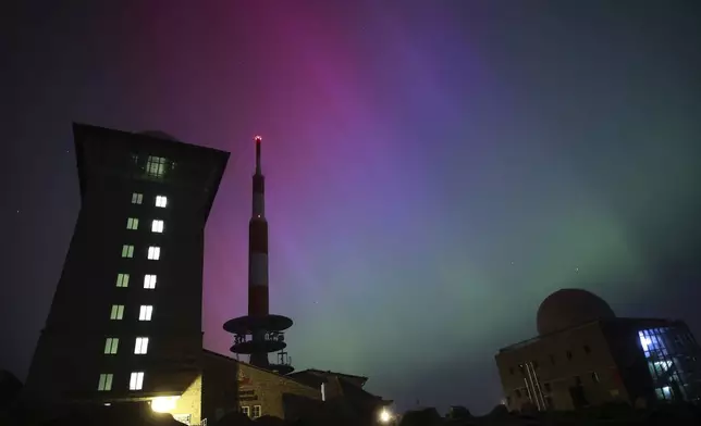 Northern lights appear in the night sky above the Brocken early Saturday, May 11, 2024, in Schierke, northern Germany. (Matthias Bein/dpa via AP)