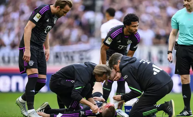 Munich's Eric Dier lies injured on the pitch as he receives treatment, during the German Bundesliga soccer match between Bayern Munich and VfB Stuttgart, in Stuttgart, Germany, Saturday, May 4, 2024. (Tom Weller/dpa via AP)