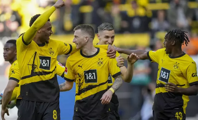 Dortmund’s Felix Nmecha, left, celebrates with his teammate Marco Reus after he scored his side's fifth goal during the German Bundesliga soccer match between Borussia Dortmund and Augsburg, in Dortmund, Saturday, May 4, 2024. (AP Photo/Martin Meissner)