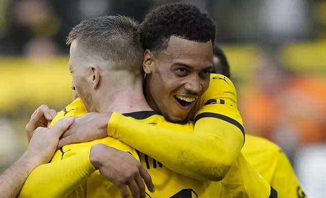 Dortmund's Felix Nmecha, right, celebrates with his teammate Marco Reus after he scored his side's fifth goal during the German Bundesliga soccer match between Borussia Dortmund and Augsburg, in Dortmund, Saturday, May 4, 2024. (AP Photo/Martin Meissner)