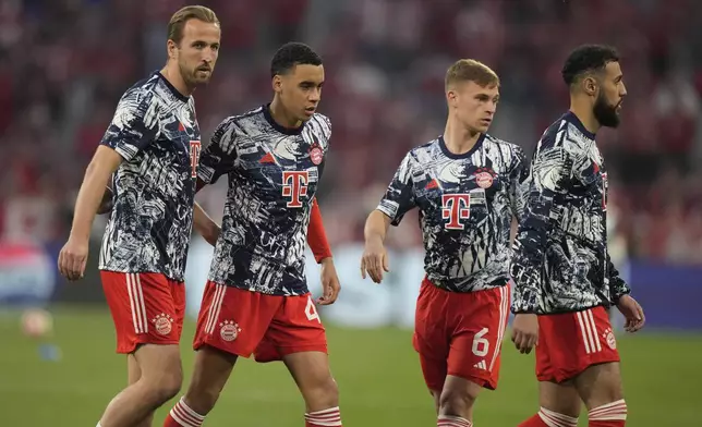 Bayern's Harry Kane, left, Bayern's Jamal Musiala, second left, Bayern's Noussair Mazraoui, right, and Bayern's Joshua Kimmich warm up prior to the Champions League semifinal first leg soccer match between Bayern Munich and Real Madrid at the Allianz Arena in Munich, Germany, Tuesday, April 30, 2024. (AP Photo/Matthias Schrader)