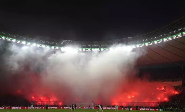 Kaiserslauter fans lit flares during the German Soccer Cup final match between 1. FC Kaiserslautern and Bayer Leverkusen at the Olympic Stadium in Berlin, Germany, Saturday, May 25, 2024. (AP Photo/Matthias Schrader)