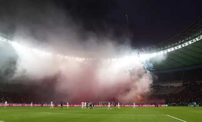 Kaiserslauter fans lit flares during the German Soccer Cup final match between 1. FC Kaiserslautern and Bayer Leverkusen at the Olympic Stadium in Berlin, Germany, Saturday, May 25, 2024. (AP Photo/Matthias Schrader)
