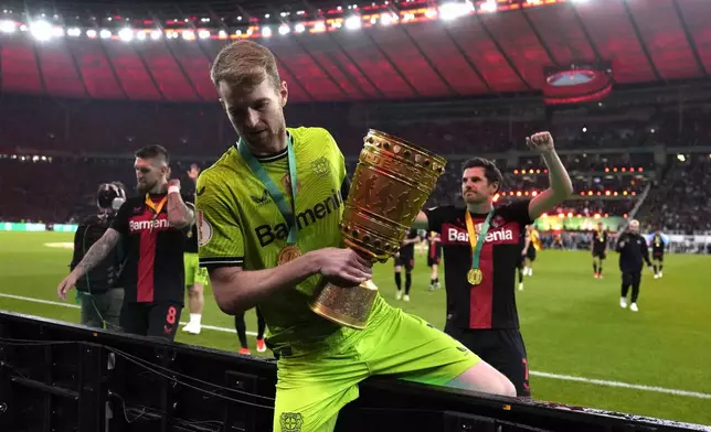 Leverkusen's goalkeeper Lukas Hradecky lifts the trophy after the German Soccer Cup final match between 1. FC Kaiserslautern and Bayer Leverkusen at the Olympic Stadium in Berlin, Germany, Saturday, May 25, 2024. (AP Photo/Matthias Schrader)
