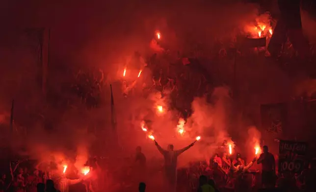 Leverkusen fans lit flares during the German Soccer Cup final match between 1. FC Kaiserslautern and Bayer Leverkusen at the Olympic Stadium in Berlin, Germany, Saturday, May 25, 2024. (AP Photo/Matthias Schrader)