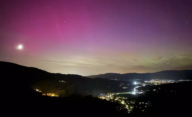 Northern lights appear over the Dreisamtal valley in the Black Forest near Freiburg, Germany, Friday evening, May 10, 2024. (Valentin Gensch/dpa via AP)