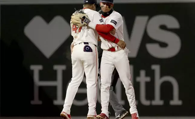 Boston Red Sox second baseman Enmanuel Valdez, left, and outfielder Ceddanne Rafaela, right, hug at the end of a baseball game against the San Francisco Giants, Wednesday, May 1, 2024, in Boston. (AP Photo/Mark Stockwell)