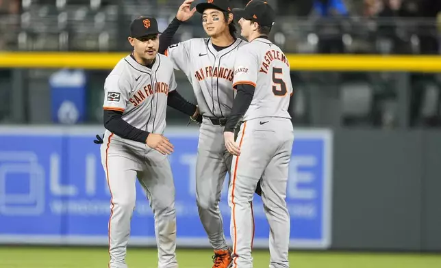 San Francisco Giants left fielder Michael Conforto, center fielder Jung Hoo Lee and right fielder Mike Yastrzemski, from left, celebrate after the team's win in a baseball game against the Colorado Rockies on Wednesday, May 8, 2024, in Denver. (AP Photo/David Zalubowski)