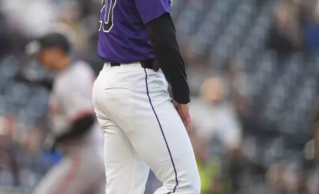 Colorado Rockies starting pitcher Peter Lambert waits after giving up a solo home run to San Francisco Giants' Michael Conforto, back, during the second inning of a baseball game Wednesday, May 8, 2024, in Denver. (AP Photo/David Zalubowski)