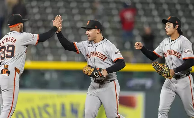From left, San Francisco Giants second base Thairo Estrada, left fielder Michael Conforto and center fielder Jung Hoo Lee celebrate after a baseball game against the Colorado Rockies Tuesday, May 7, 2024, in Denver. (AP Photo/David Zalubowski)
