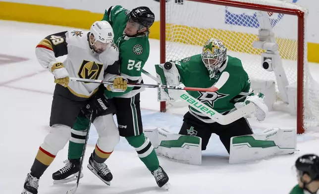 Dallas Stars goaltender Jake Oettinger, right, blocks a shot as teammate Roope Hintz (24) defends against Vegas Golden Knights center Tomas Hertl (48) during the first period in Game 7 of an NHL hockey Stanley Cup first-round playoff series, Sunday, May 5, 2024, in Dallas. (AP Photo/Brandon Wade)