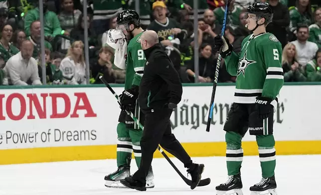 Dallas Stars' Tyler Seguin, left, is escorted off the ice by a staff member and Nils Lundkvist, after taking a hit to the face by Vegas Golden Knights' Alex Pietrangelo in the second period in Game 5 of an NHL hockey Stanley Cup first-round playoff series in Dallas, Wednesday, May 1, 2024. Pietrangelo recieved a penalty on the play. (AP Photo/Tony Gutierrez)