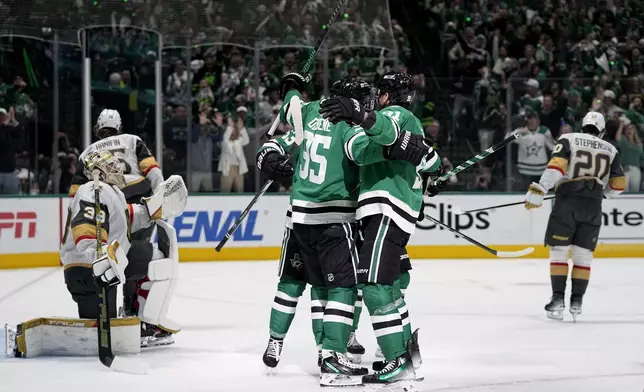 Dallas Stars' Matt Duchene and Tyler Seguin, center right, and others celebrate a goal scored by Duchene as Vegas Golden Knights' Adin Hill (33) looks on in the first period in Game 5 of an NHL hockey Stanley Cup first-round playoff series in Dallas, Wednesday, May 1, 2024. (AP Photo/Tony Gutierrez)