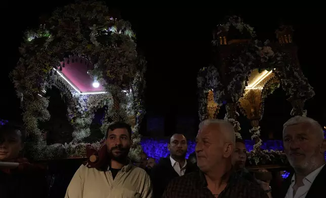 The processions from the two main parishes, known as "Epitaphios", the bier that carries the body of Jesus Christ to his grave, meet at the Venetian port, in Nafpaktos town, western Greece, on Good Friday, May 3, 2024. The solemn processions in Greece, with the flower-adorned biers followed by the clergy and the faithful, are often spectacular, especially in places where bier processions from each parish converge into a central square. (AP Photo/Thanassis Stavrakis)