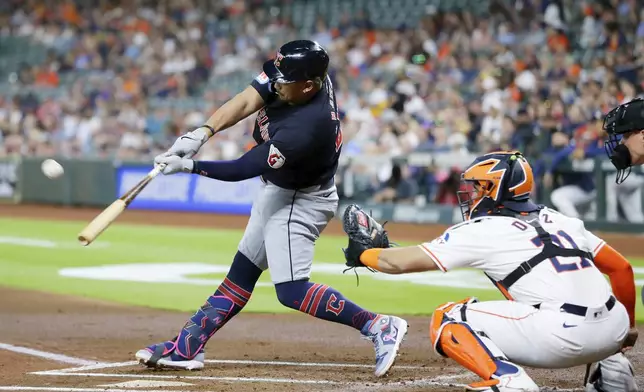 Cleveland Guardians' Josh Naylor, left, connects for a three run home run in front of Houston Astros catcher Yainer Diaz, right, during the first inning of a baseball game Tuesday, April 30, 2024, in Houston. (AP Photo/Michael Wyke)