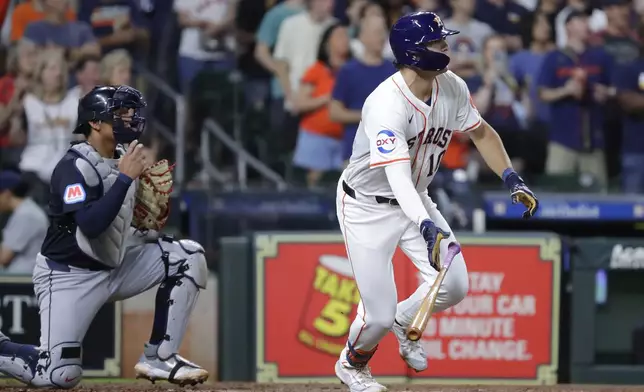 Houston Astros' Joey Loperfido, right, flips his bat as he heads to first base on his two run RBI single in front of Cleveland Guardians catcher Bo Naylor, left, during the fourth inning of a baseball game Tuesday, April 30, 2024, in Houston. Loperfido's hit was his first in the major leagues. (AP Photo/Michael Wyke)