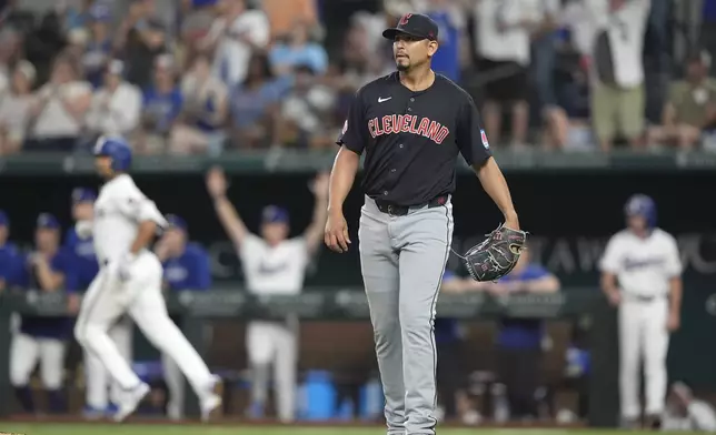 Cleveland Guardians starting pitcher Carlos Carrasco, right, watches as the home run hit by Texas Rangers' Marcus Semien clears the fence during the fifth inning of a baseball game in Arlington, Texas, Wednesday, May 15, 2024. Rangers Leody Taveras also scored on the play. (AP Photo/LM Otero)