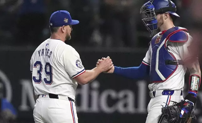 Texas Rangers closer pitcher Kirby Yates (39) gets a congratulations from teammate catcher Jonah Heim after the final out of the ninth inning of a baseball game against the Cleveland Guardians in Arlington, Texas, Wednesday, May 15, 2024. (AP Photo/LM Otero)