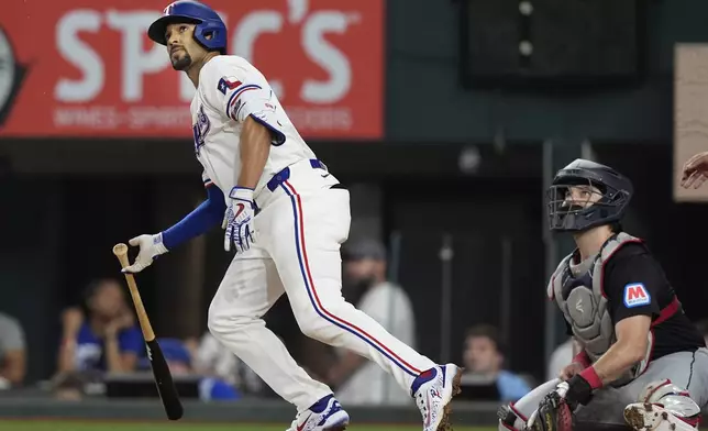 Texas Rangers' Marcus Semien, left, and Cleveland Guardians catcher Austin Hedges watch Semien's home run get away during the fifth inning of a baseball game in Arlington, Texas, Wednesday, May 15, 2024. Rangers Leody Taveras also scored on the play. (AP Photo/LM Otero)