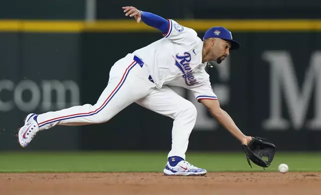 Texas Rangers second base Marcus Semien fields an infield grounder for the out at first base against Cleveland Guardians' Gabriel Arias during the second inning of a baseball game in Arlington, Texas, Wednesday, May 15, 2024. (AP Photo/LM Otero)