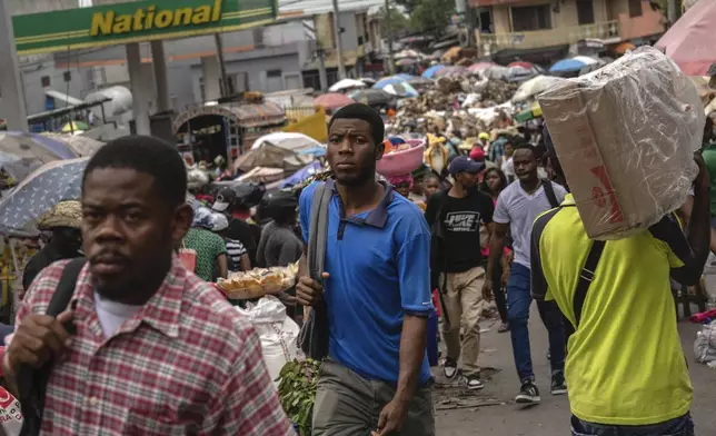 People walk through a street market in Port-au-Prince, Haiti, Friday, April 26, 2024. (AP Photo/Ramon Espinosa)