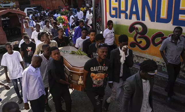 Friends and family accompany the coffin that contain the remains of Jhon-Roselet Joseph, killed by a stray bullet during clashes between police, and gang members who were trying to invade the Solino neighborhood, during a funeral procession in Port-au-Prince, Haiti, Saturday, May 18, 2024 (AP Photo/Ramon Espinosa)
