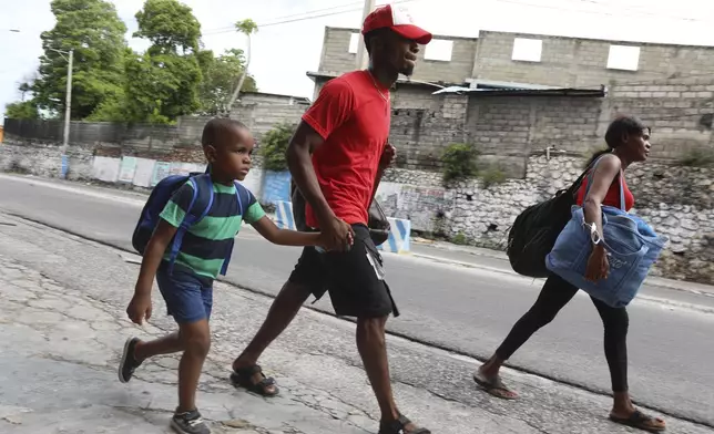 Residents walk down a hill as they flee their homes in the Delmas 22 neighborhood to escape gang violence in Port-au-Prince, Haiti, Thursday, May 2, 2024. (AP Photo/Odelyn Joseph)