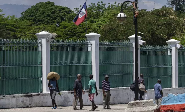 People walk past the National Nalace in Port-au-Prince, Haiti, Tuesday, April 23, 2024. (AP Photo/Ramon Espinosa)