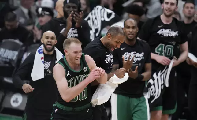 Boston Celtics forward Sam Hauser (30) is congratulated after hitting a 3-pointer against the Miami Heat during the second half of Game 5 of an NBA basketball first-round playoff series, Wednesday, May 1, 2024, in Boston. (AP Photo/Charles Krupa)