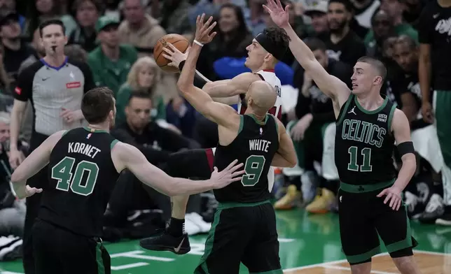 Miami Heat guard Tyler Herro, center, tries to drive to the basket against the Boston Celtics during the second half of Game 5 of an NBA basketball first-round playoff series, Wednesday, May 1, 2024, in Boston. (AP Photo/Charles Krupa)