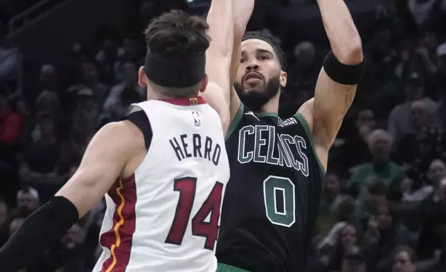 Boston Celtics forward Jayson Tatum (0) shoots over Miami Heat guard Tyler Herro (14) during the first half of Game 5 of an NBA basketball first-round playoff series, Wednesday, May 1, 2024, in Boston. (AP Photo/Charles Krupa)