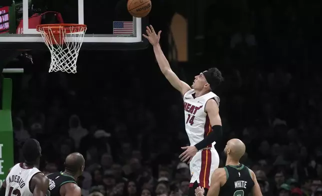 Miami Heat guard Tyler Herro (14) tosses up a shot after driving past Boston Celtics guard Derrick White (9) during the first half of Game 5 of an NBA basketball first-round playoff series, Wednesday, May 1, 2024, in Boston. (AP Photo/Charles Krupa)