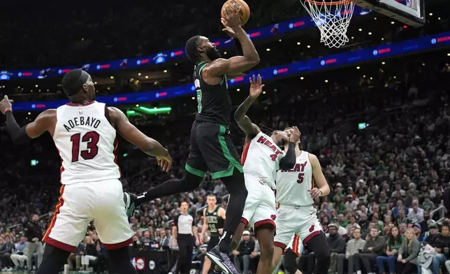 Boston Celtics guard Jaylen Brown (7) drives past Miami Heat center Bam Adebayo (13) during the first half of Game 5 of an NBA basketball first-round playoff series, Wednesday, May 1, 2024, in Boston. (AP Photo/Charles Krupa)
