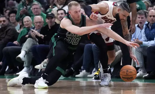 Boston Celtics forward Sam Hauser (30) battles Miami Heat forward Caleb Martin for the ball during the first half of Game 5 of an NBA basketball first-round playoff series, Wednesday, May 1, 2024, in Boston. (AP Photo/Charles Krupa)