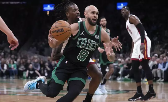 Boston Celtics guard Derrick White (9) drives to the basket past Miami Heat guard Delon Wright, center rear, during the first half of Game 5 of an NBA basketball first-round playoff series, Wednesday, May 1, 2024, in Boston. (AP Photo/Charles Krupa)