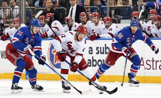 New York Rangers right wing Kaapo Kakko (24), left wing Will Cuylle (50) and Carolina Hurricanes center Jesperi Kotkaniemi (82) fight for the puck during the first period in Game 2 of an NHL hockey Stanley Cup second-round playoff series, Tuesday, May 7, 2024, in New York. (AP Photo/Julia Nikhinson)