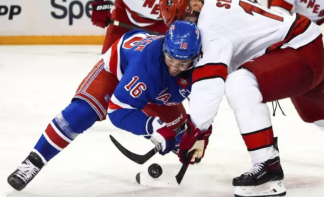 New York Rangers center Vincent Trocheck (16) and Carolina Hurricanes center Jordan Staal fight for the puck during the first period in Game 1 of an NHL hockey Stanley Cup second-round playoff series, Sunday, May 5, 2024, in New York. (AP Photo/Julia Nikhinson)