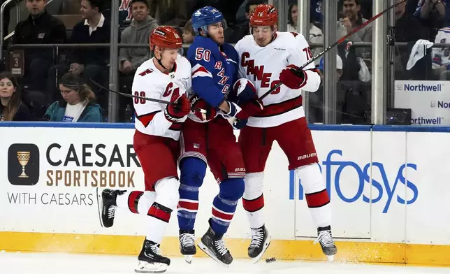 Carolina Hurricanes center Martin Necas, defenseman Brady Skjei and New York Rangers left wing Will Cuylle fight for the puck during the first period in Game 1 of an NHL hockey Stanley Cup second-round playoff series, Sunday, May 5, 2024, in New York. (AP Photo/Julia Nikhinson)