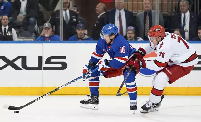 New York Rangers left wing Artemi Panarin (10) and Carolina Hurricanes defenseman Brady Skjei (76) fight for the puck during the third period in Game 1 of an NHL hockey Stanley Cup second-round playoff series, Sunday, May 5, 2024, in New York. (AP Photo/Julia Nikhinson)