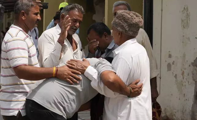 Relatives of 21-year-old Surpalsinh Jadeja break down after hearing of his death at a government hospital hours after a massive fire killed 27 people, including children, who were enjoying a weekend visit to an amusement park in the city of Rajkot, India, Sunday, May 26, 2024. (AP Photo/Ajit Solanki)