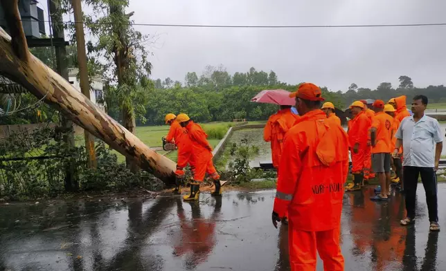 India's National Disaster Response Force (NDRF) rescuers remove fallen trees as they oversee damages in Cyclone Remal affected villages in West Bengal state, India, Monday, May 27, 2024. (NDRF via AP)