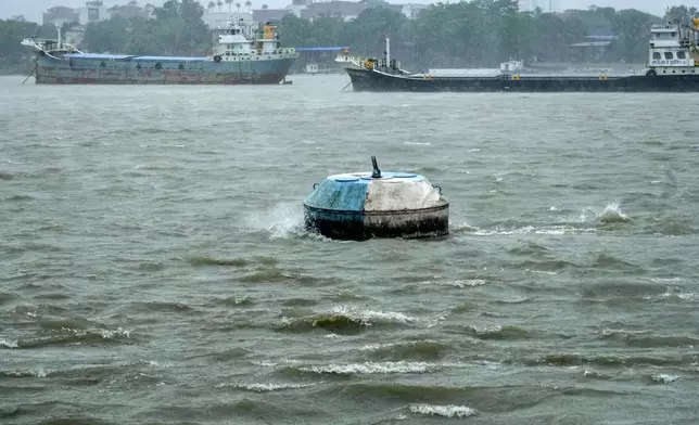 A buoy stands amidst the thrush of water on the Hooghly River in Kolkata, India, as rain continues after cyclone Remal made a landfall near Bangladesh-India border, Monday, May 27, 2024. (AP Photo/Bikas Das)