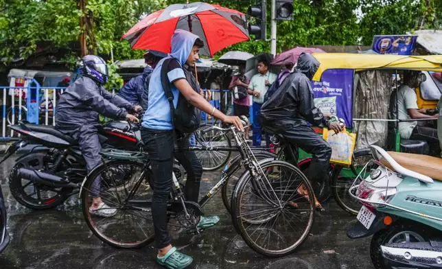 Commuters wait during a traffic jam in Kolkata, India, as rain continues after cyclone Remal made a landfall near Bangladesh-India border, Monday, May 27, 2024. (AP Photo/Bikas Das)